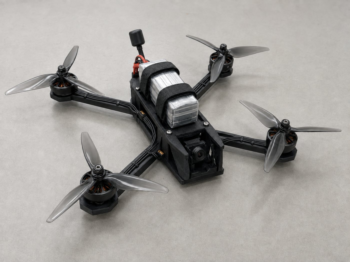 WETWORX target drone, FPV configuration: printed quadrotor frame, four motors, strapped lithium pack, nose-mounted camera and whip antenna.